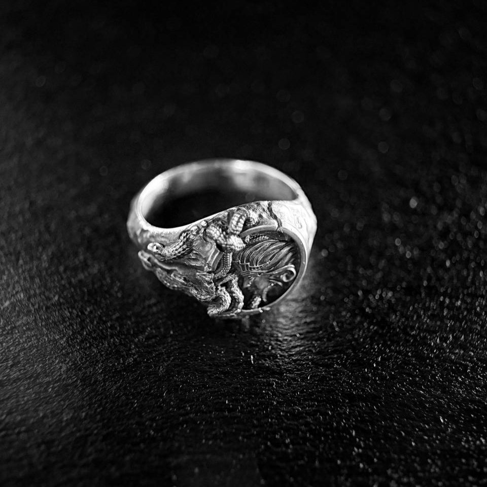Silver 925 Medusa Ring with intricate design on a black textured surface